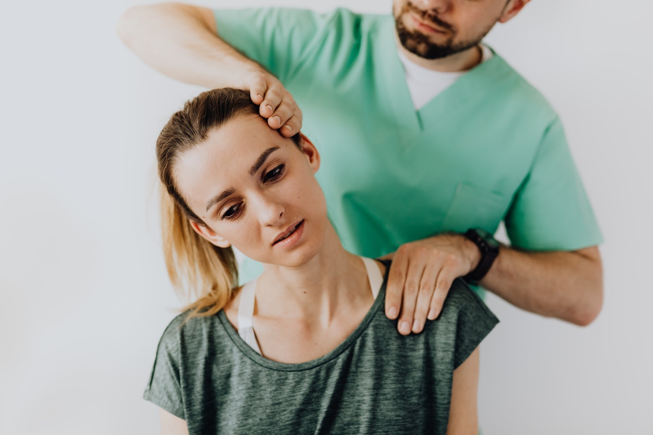 professional physical therapist treating young women in his clinic