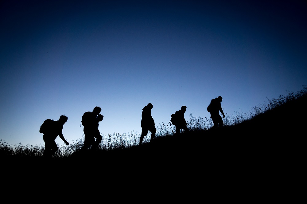 group of people hiking on mountain during early morning