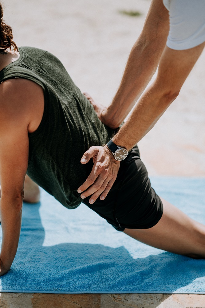 physical therapist pressing man back outdoor during day time