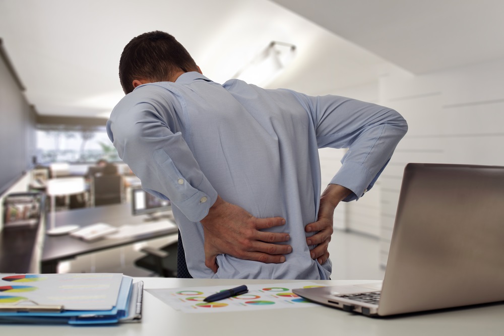 man with back pain an office